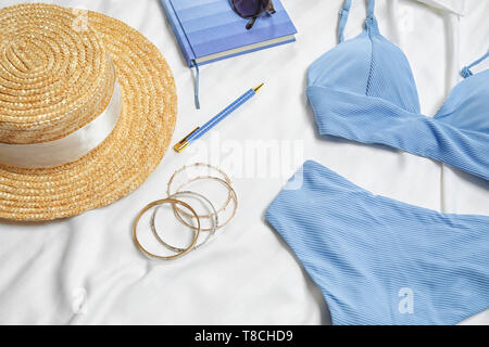 Komposition mit Badebekleidung und Zubehör auf Bettwäsche Stockfoto