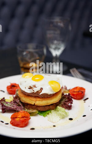 Gourmet Burger mit Kartoffel Patty und Omelette Restaurant Tabelle Stockfoto