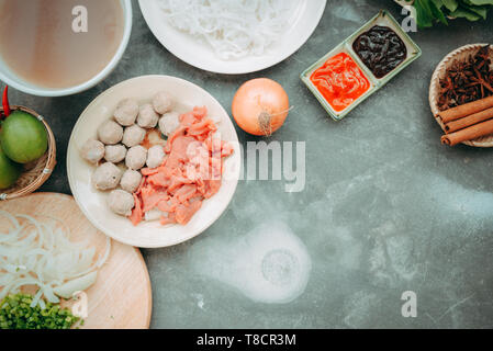 Traditionelle vietnamesische Nudelsuppe pho in Schalen, konkreten Hintergrund. Vietnamesische Rindfleisch Suppe pho bo, Close-up. Asiatische und vietnamesische Küche. Vietnamesische Abendessen Stockfoto