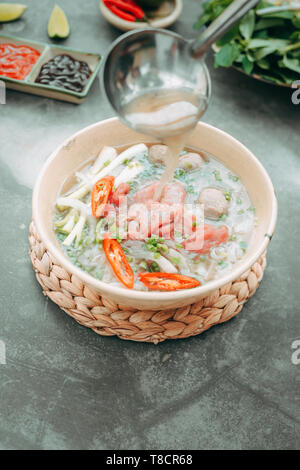 Pho Bo-vietnamesischen frischen Reis Nudelsuppe mit Rindfleisch, Kräuter und Chili. Lieferbar wird gegossen. Vietnams Nationalgericht. Stockfoto