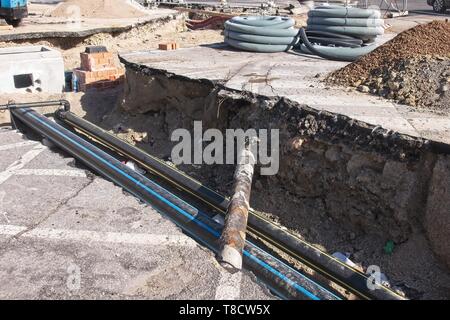 Bauindustrie. Straßenarbeiten. Ausgrabung und Verlegung von Gasleitungen. Verlegung der Rohre für Glasfaser. Stockfoto