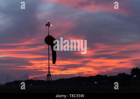 BADUNG BALI - 14. APRIL 2019: Windsack unter in der Morgendämmerung unter der rot orange leuchtende Himmel mit Cirrus und cumulus Wolken Stockfoto