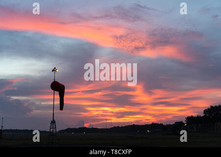 BADUNG BALI - 14. APRIL 2019: Windsack unter in der Morgendämmerung unter der rot orange leuchtende Himmel mit Cirrus und cumulus Wolken Stockfoto