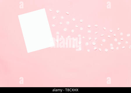 Eine Anordnung von Blumen und Papier Karten auf rosa Hintergrund Stockfoto