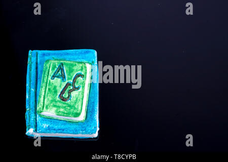 Kleines Buch als Dekoration mit den Buchstaben ABC auf schwarzem Hintergrund und freien Speicherplatz für Text für Schule starter Stockfoto