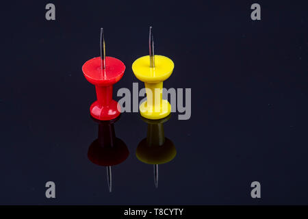 Die beiden Stifte in der Farbe Rot und Gelb auf schwarzem Hintergrund Stockfoto