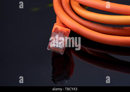 Orange Datenkabel für schnelles Internet auf schwarzem Hintergrund für eine moderne Installation in Ihrem Zuhause Stockfoto