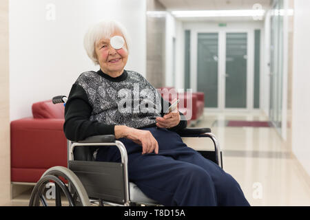 Lonley Alter 95 Jahre alte Frau im Rollstuhl mit modernen Handy sitzen. Stockfoto