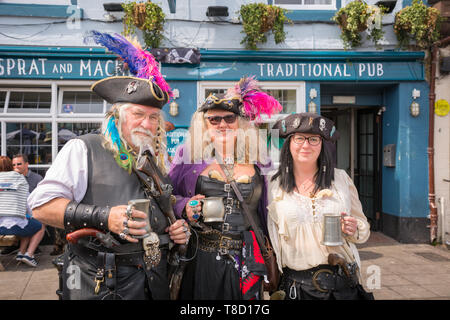 Drei verkleidet als Piraten und Trinken auf der Straße während der Pirat festival Wochenende Brixham, Devon, Großbritannien Stockfoto