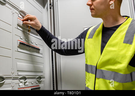 Männliche Elektriker prüfen elektrische Sicherung im Serverraum Stockfoto