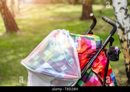 Kind im Kinderwagen mit schützenden Netz während Spaziergang abgedeckt. Kinderwagen mit Anti-mücken-Abdeckung. Midge-Schutz für Kinder während Outdoor Stockfoto