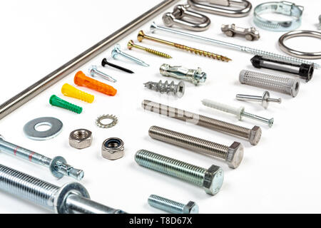Eine Zusammenstellung der Zimmerleute Material wie Schrauben, Dübel, Muttern Schrauben und Nägel auf einem weißen Hintergrund. Stockfoto