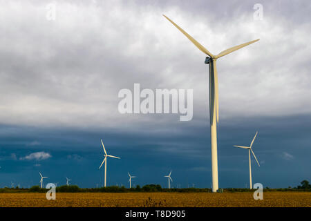 Windenergieanlage bei einem bewölkten Tag auf einem Bauernhof. Stockfoto
