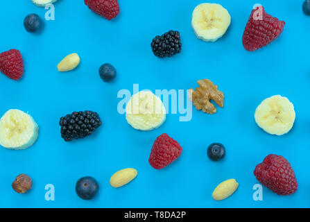 Horinztal Blick auf viele verschiedene gesunde Nüsse Obst und Beeren auf einem blauen Hintergrund Stockfoto