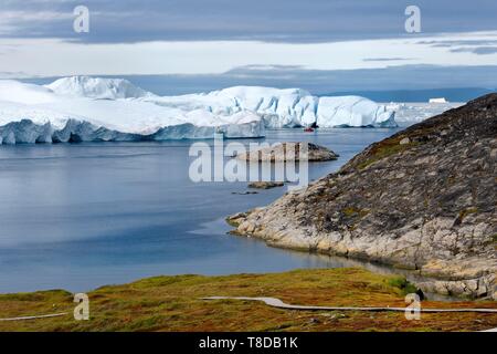 Grönland, Westküste, Diskobucht, Ilulissat Icefjord UNESCO Weltkulturerbe, ist die Mündung des Sermeq Kujalleq Jakobshavn Gletscher (Gletscher), Wandern auf dem Holzsteg der Sermermiut Website und Fischerboot am Fuße der Eisberge gehen Stockfoto