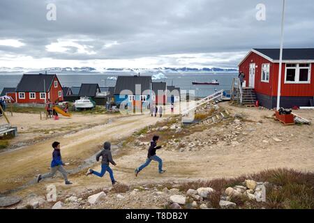 Grönland, North West Coast, oder Neue Thule Qaanaaq, Inuit Kinder führen ihre Lehrerin, ein Eisberg im Hintergrund Stockfoto