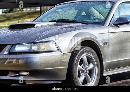 2001 Ford Mustang GT Coupé glitzert in der Sonne nach einem Sommer Sturm. Glitzernde Wassertropfen Abdeckung der Körper des Sportwagens. Stockfoto