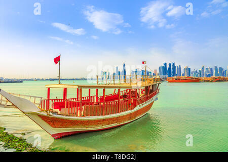 Blick von einem traditionellen hölzernen Dhow vorne, mit Küste von Doha Bucht und Wolkenkratzer von West Bay Skyline im Hintergrund. Hauptstadt Stockfoto