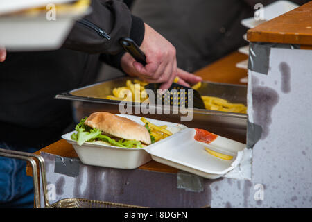 Vorbereitung nehmen Sie Essen mit frisch zubereiteten Burger und Pommes frites auf Freizeit Küche an Street Music Festival in der Stopfbuchse, Waadt, Schweiz Stockfoto