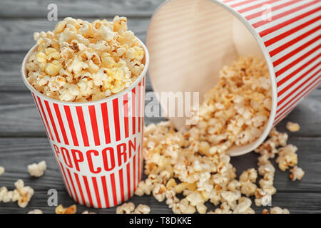 Cups mit lecker Popcorn auf hölzernen Hintergrund, Nahaufnahme Stockfoto