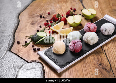 Schiefer Teller mit leckeren Eis und andere Zutaten auf Tisch Stockfoto