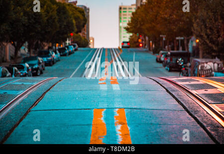 Low Angle Dämmerung Blick auf eine leere Straße mit Seilbahn Tracks, die einen steilen Hügel an der berühmten California Street im Morgengrauen, San Francisco, Kalifornien, USA, Stockfoto