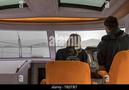 Die Bucht von Kotor, Montenegro, 29. April 2019: ein junges Paar, das Navigieren in der Geschwindigkeit Yacht im Regen Stockfoto