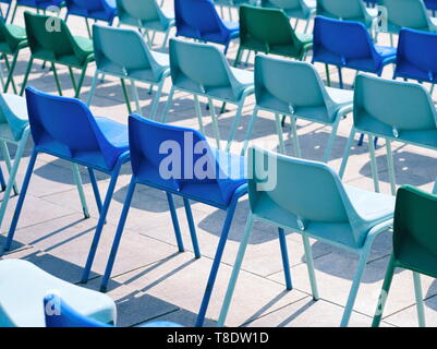 Vielen leeren, blauen Kunststoff Stühle im Freien an einem sonnigen Tag Stockfoto