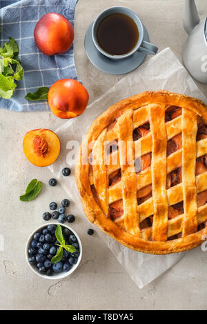 Köstliche peach Pie, Heidelbeere und Tasse Tee auf Licht Tabelle Stockfoto