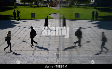 Stuttgart, Deutschland. 13. Mai, 2019. Fußgänger sind in eine Scheibe (r) wider. Credit: Sebastian Gollnow/dpa/Alamy leben Nachrichten Stockfoto