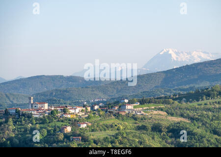 Kleines Dorf Šmartno in Rebsorten Region Goriška Brda in Slowenien mit Schnee bedeckt die Julischen Alpen am Horizont Stockfoto