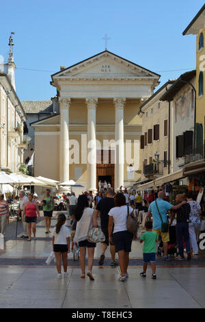 Touristen auf der Piazza Giacomo Matteotti mit der Kirche San Nicolo und Severo Bardolino am Gardasee - Italien. Stockfoto