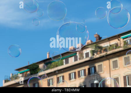 Bunte Seifenblasen fliegen über Gebäude an der Piazza Navona in Rom. Italien. Stockfoto