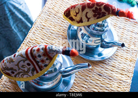 Marokkanischen Tee mit Minze und Zucker in einer Brille auf eine Kupferplatte mit Wasserkocher. Marokko Stockfoto