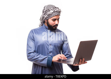 Junge arabische Mann in traditioneller Kleidung mit Laptop auf weißem Hintergrund Stockfoto