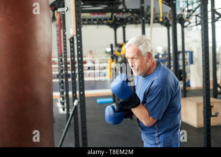 Ältere männliche Boxer bereit zu kämpfen. Senior Boxer in Handschuhe Boxing in der Turnhalle. Stockfoto