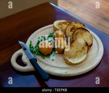 Einen Snack bestehend aus Toast und gebratener Ziegenkäse auf Holztisch, zentriert, mit Kopie Raum Stockfoto