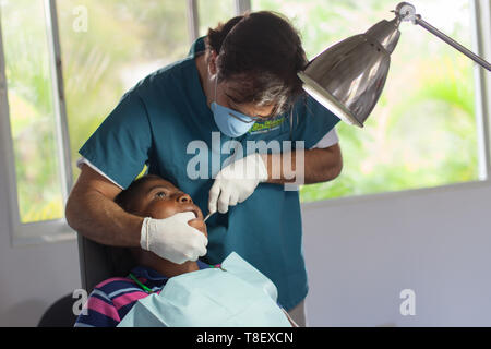 Sosúa, Provinz Puerto Plata, Dominikanische Republik - 11. Mai 2013: Freiwilliger Zahnarzt, der in der medizinischen Einrichtung Monkey Jungle an einem Kind in der Dominikanischen Republik arbeitet. Stockfoto