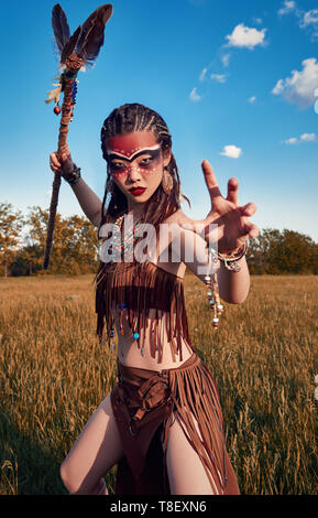 Outdoor Portrait der schönen jungen Schamanin (Witch Doctor) in Feld bei Sonnenuntergang. Schöne Schamane (Zauberin) Vorbereitung zur Bekämpfung Stockfoto