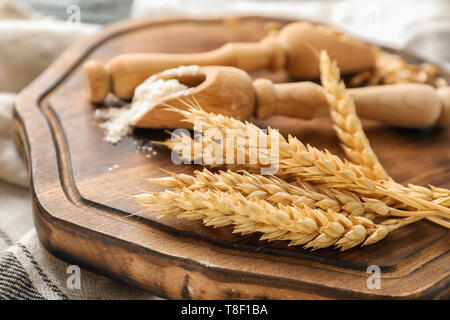 Schaufel mit Mehl und Weizen ährchen auf Holzbrett Stockfoto