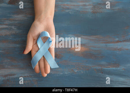 Frau mit blauen Band auf Holz- Hintergrund. Prostatakrebs Konzept Stockfoto