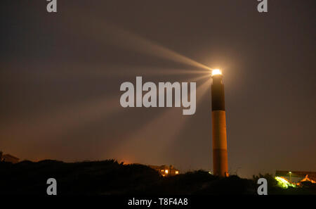 Die Oak Island Leuchtturm strahlt Licht aus 360 Grad auf Caswell Strand Stockfoto