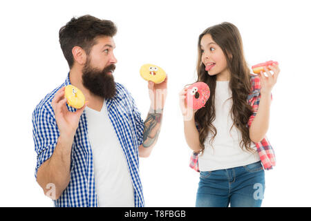 Glückliche Familie. Lassen Sie mich Ihnen helfen. kleines Kind Liebe ihr Vati. Vater und Tochter essen Donut. sich gemeinsam amüsiert. Vatertag. Tag der Kinder. familiären Bindungen. glückliche kleine Mädchen mit Vater. Donut kochen. Stockfoto