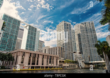 Wolkenkratzer in der Innenstadt von Miami, USA. Hohe Gebäude am Ufer des Flusses an bewölkten und blauer Himmel. Skyline und urbane Landschaft. Concrete Jungle Konzept. Perspektive und Zukunft Stockfoto