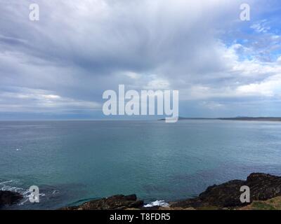 Atemberaubende Landschaft des Pazifischen Ozeans mit dramatischen, majestätischen Sturmwolken, die das blaugrüne Meer von der Ostküste Australiens aus leicht beschatten Stockfoto