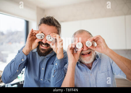 Ein Porträt von Erwachsenen hipster Sohn und Vater in Innenräumen zu Hause, Spaß zu haben. Stockfoto