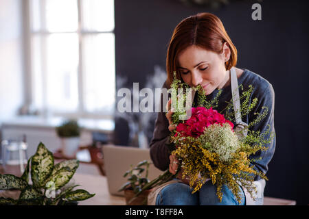 Junge kreative Frau in einem Blumenladen. Ein Anlauf von Blumengeschäft Geschäft. Stockfoto