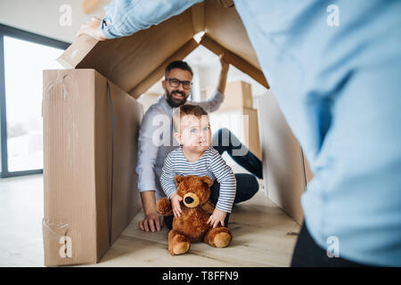 Ein Porträt der jungen Familie mit einem Kleinkind Mädchen, die sich in neuen Home Konzept. Stockfoto
