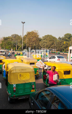 Eine Indische verkaufen Zeitungen in der hektischen Verkehr von Delhi, Indien Stockfoto