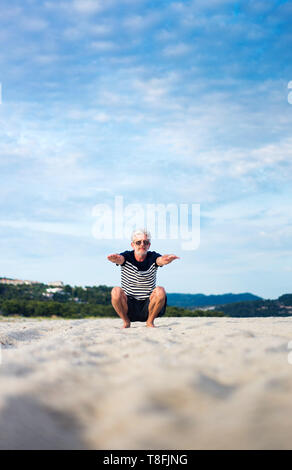 Ältere Menschen tun Stretching Übungen am Strand, Sport Abstract Stockfoto